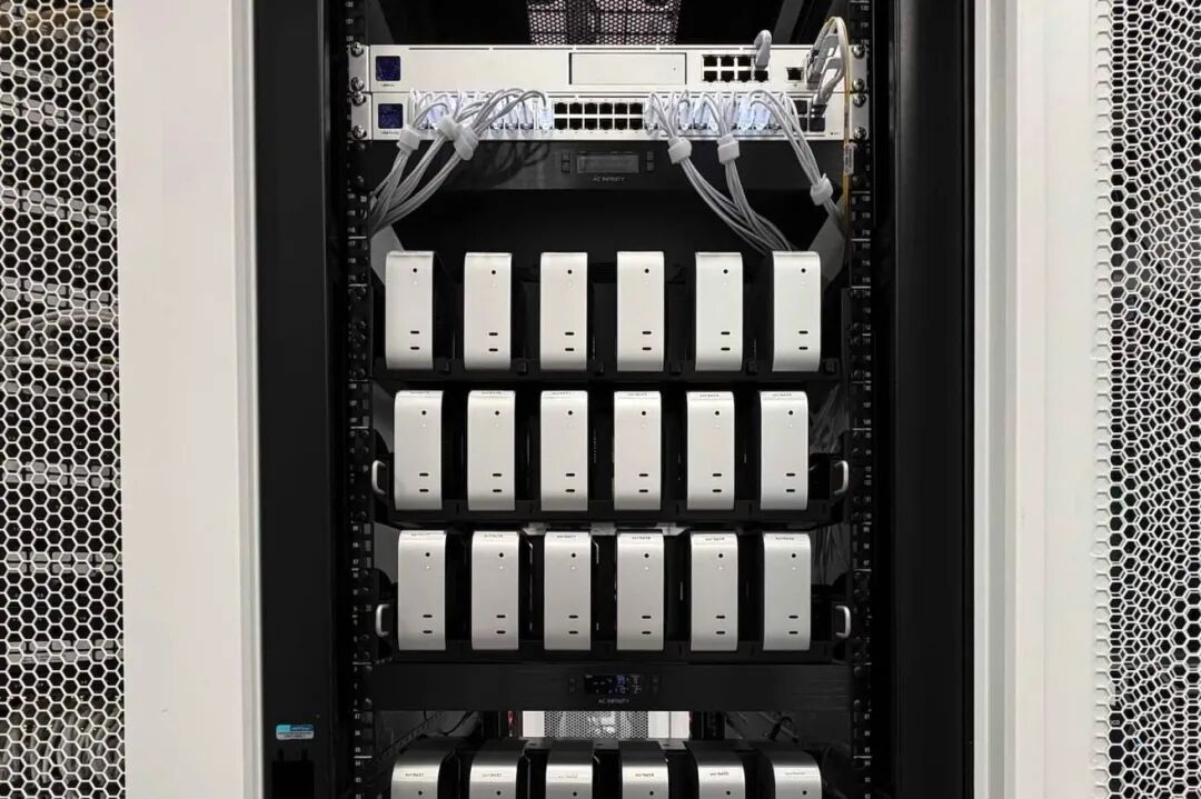 服务器机架顶部有多排紧凑型银色计算机、网络交换机和线缆，两侧面板采用六边形通风设计。